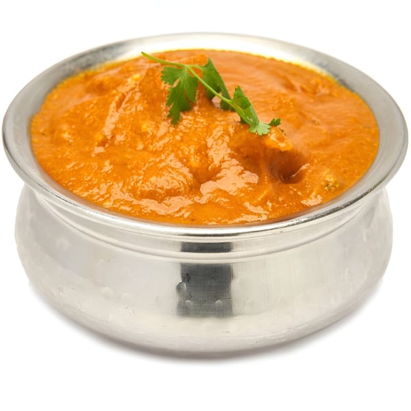 Muna's Indian butter chicken curry in a silver bowl, garnished with fresh cilantro.