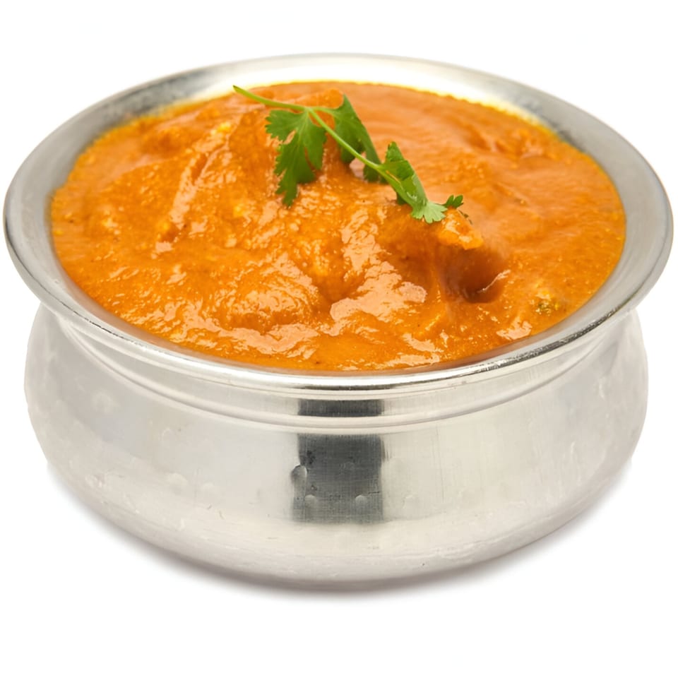 Muna's Indian butter chicken curry in a silver bowl, garnished with fresh cilantro.